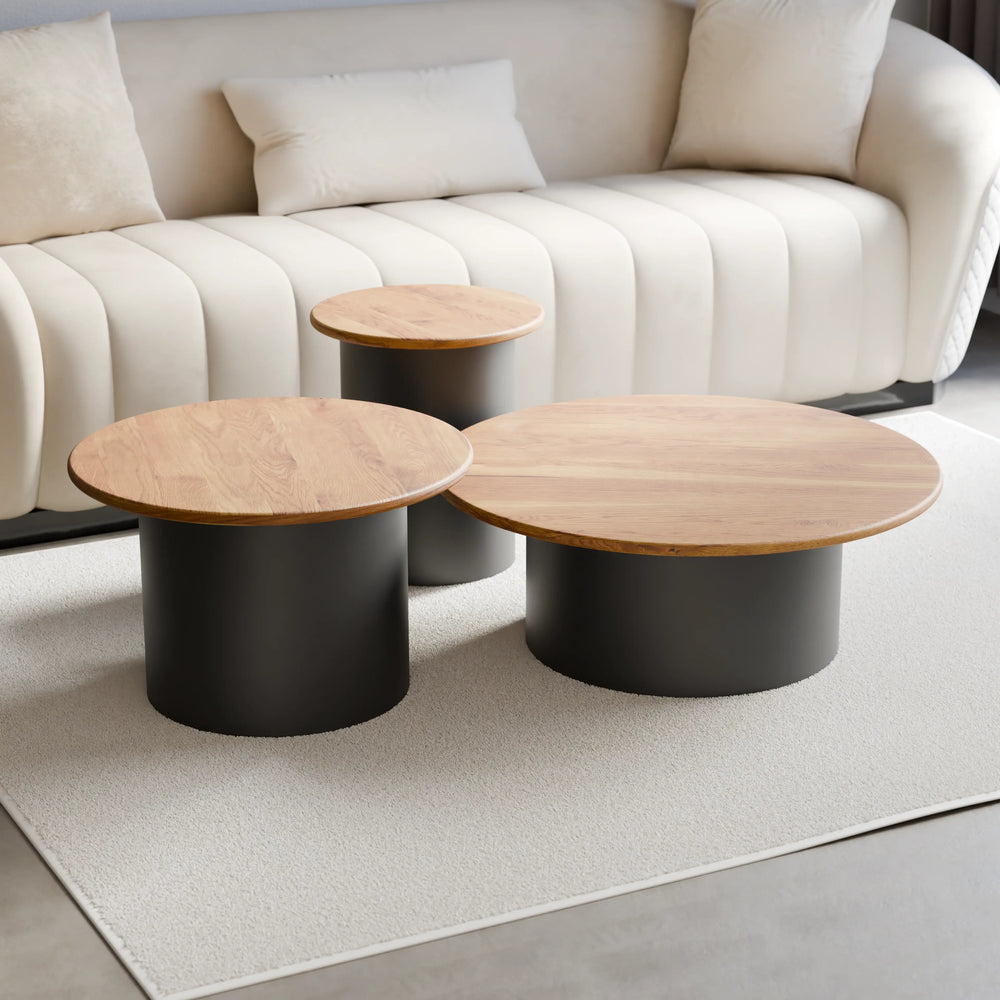 סט שולחנות סלון עגולים Tor עם פלטות עץ מלא ובסיסים גליליים שחורים בעיצוב פיסולי מודרני