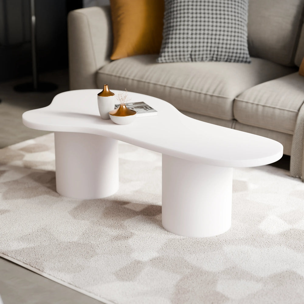 שולחן סלון אורגני בעיצוב ג'פנדי עם פלטה מחופה בצבע אפוקסי לבן ורגליים גליליות עבות.