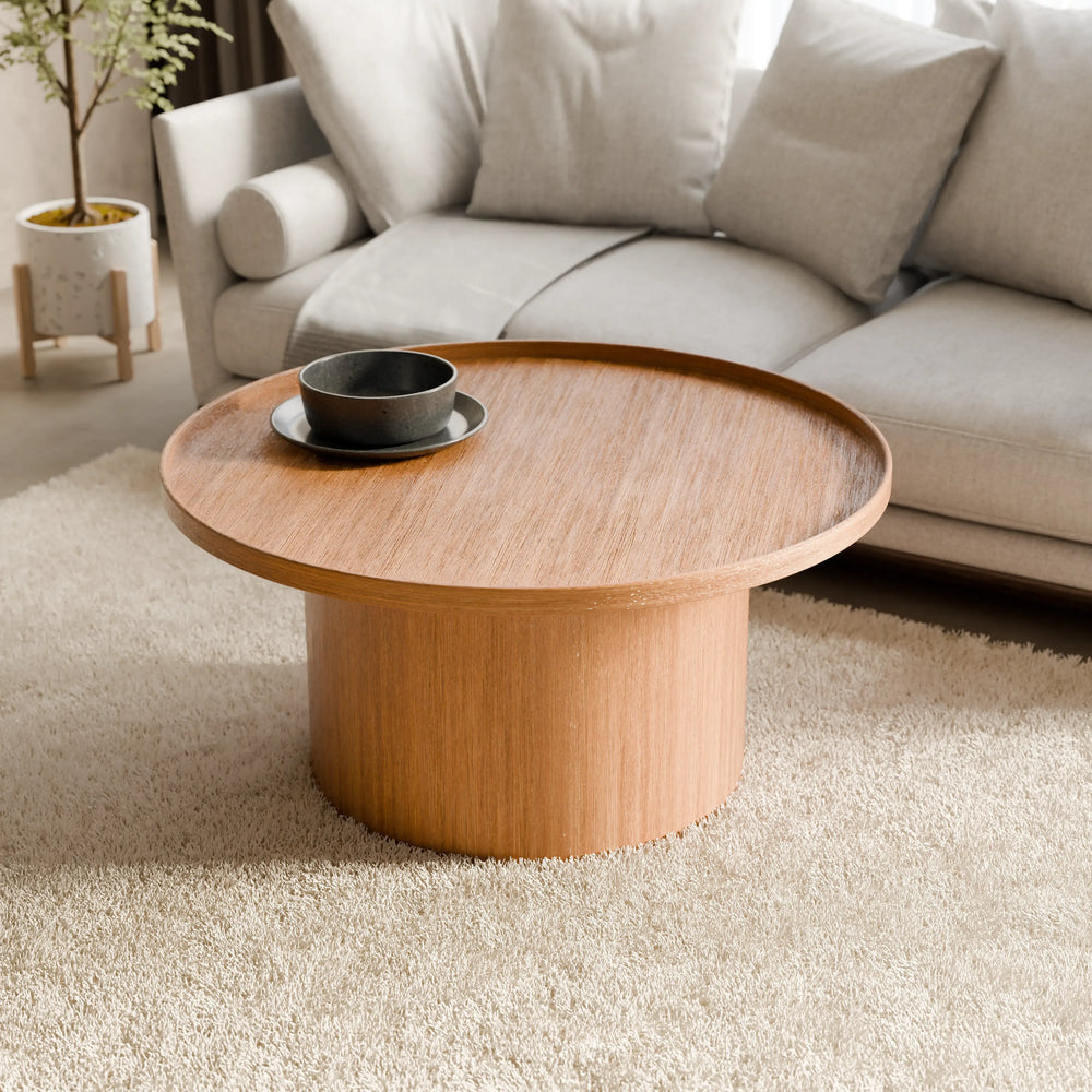 שולחן סלון עגול Lund עם פלטה מחופה פורניר אלון ובסיס גלילי בעיצוב פיסולי עכשווי