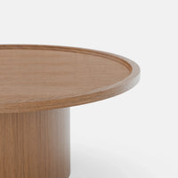 שולחן סלון עגול Sintila עם פלטה מחופה פורניר ושוליים מוגבהים בעיצוב פיסולי עכשווי