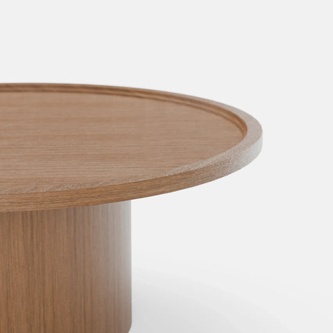 שולחן סלון עגול Sintila עם פלטה מחופה פורניר ושוליים מוגבהים בעיצוב פיסולי עכשווי