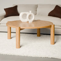 שולחן סלון עגול בעיצוב מודרני עם פלטה מחופה בפורניר טבעי ורגלי עץ מלא עבות.