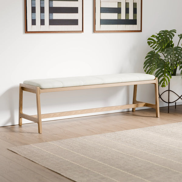 ספסל עץ מלבני ארוך בגוון אלון בהיר עם מושב מרופד לבן, מעוצב בקווים נקיים בסגנון סקנדינבי, אידיאלי כחלק מקולקציית ספסלים לחדר כניסה או מסדרון.
