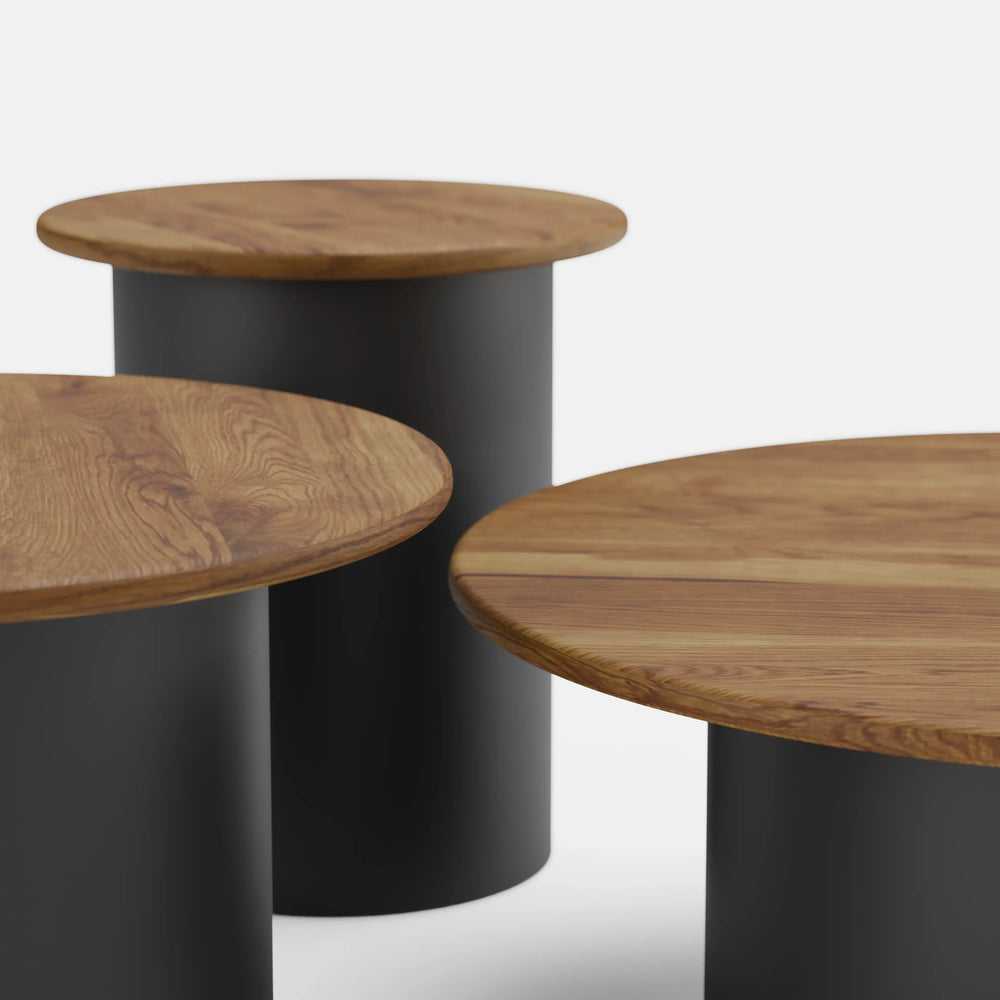 סט שולחנות סלון עגולים Tor עם פלטות עץ מלא ובסיסים גליליים שחורים בעיצוב פיסולי מודרני