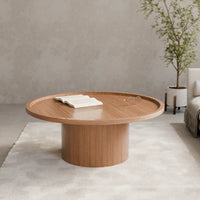 שולחן סלון עגול Sintila עם פלטה מחופה פורניר ושוליים מוגבהים בעיצוב פיסולי עכשווי