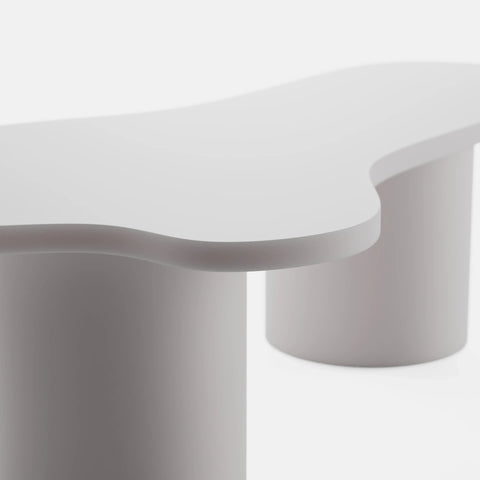 שולחן סלון אורגני בעיצוב ג'פנדי עם פלטה מחופה בצבע אפוקסי לבן ורגליים גליליות עבות.